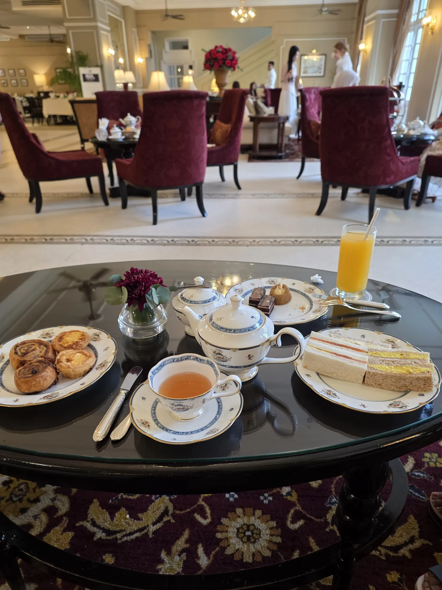 Afternoon tea with sandwiches, pastries, and a teapot at The Majestic Hotel