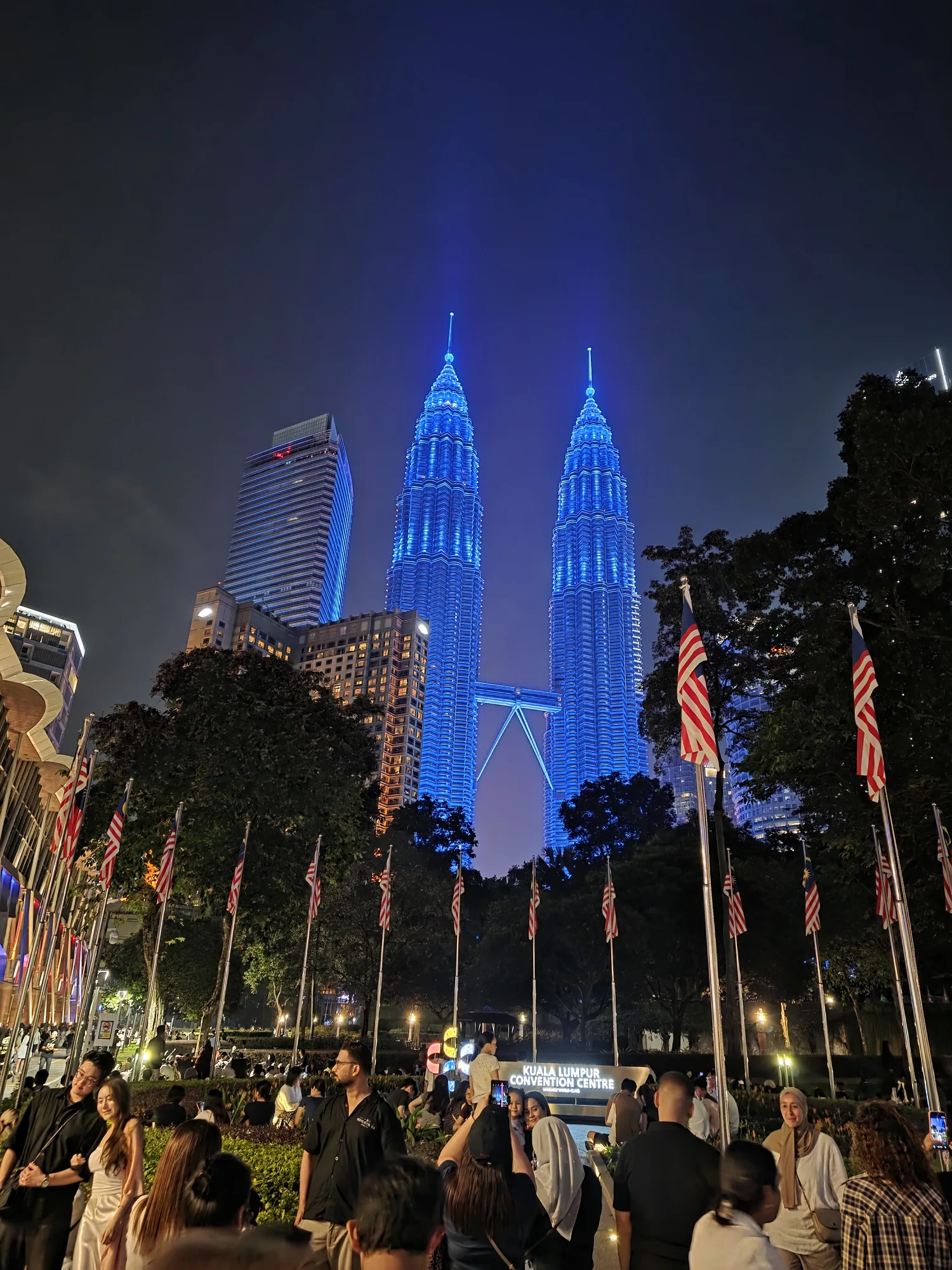 The Petronas Twin Towers lit blue above the Merdeka crowd