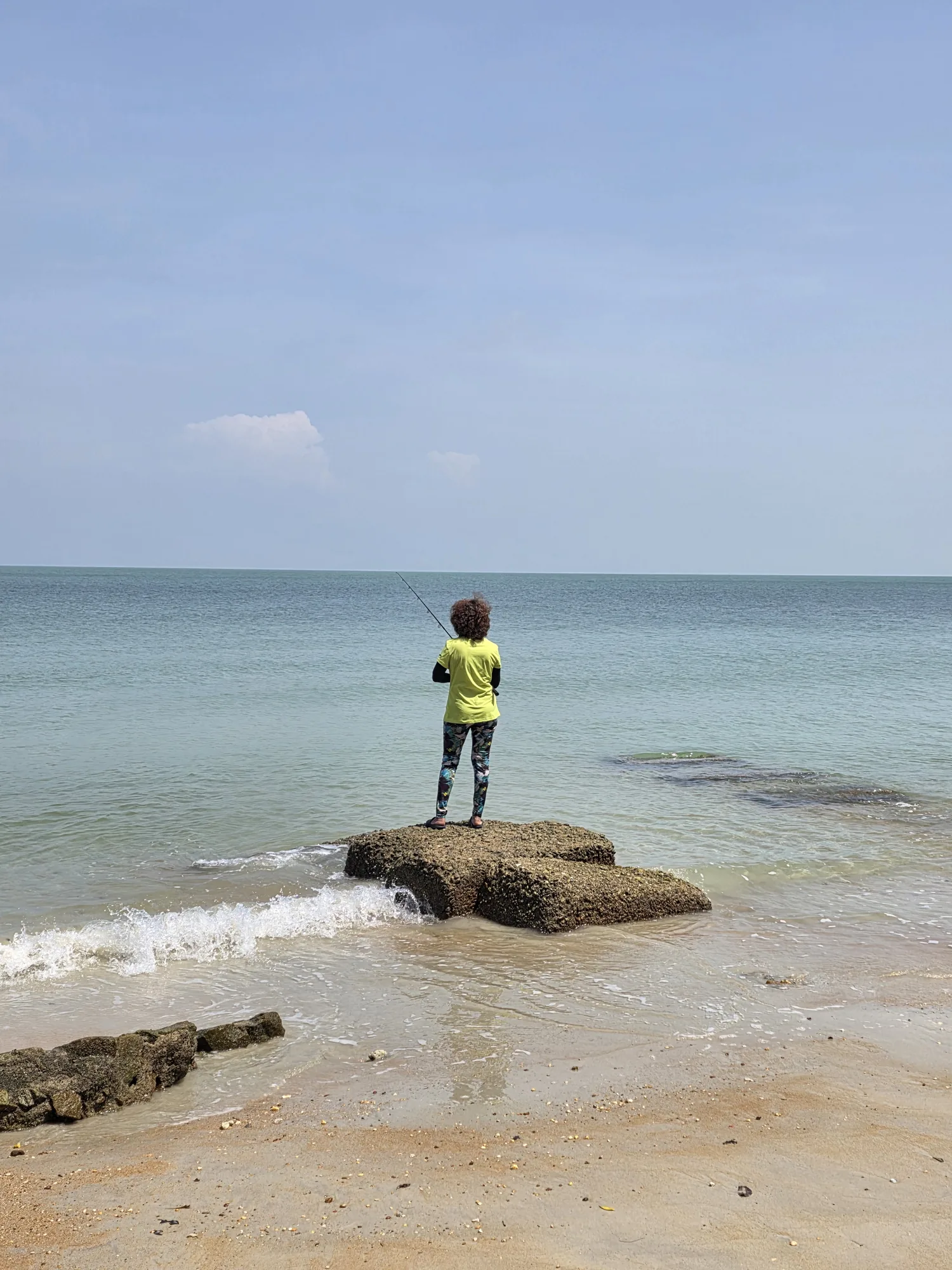 Judy fishing from a quiet beach in Port Dickson