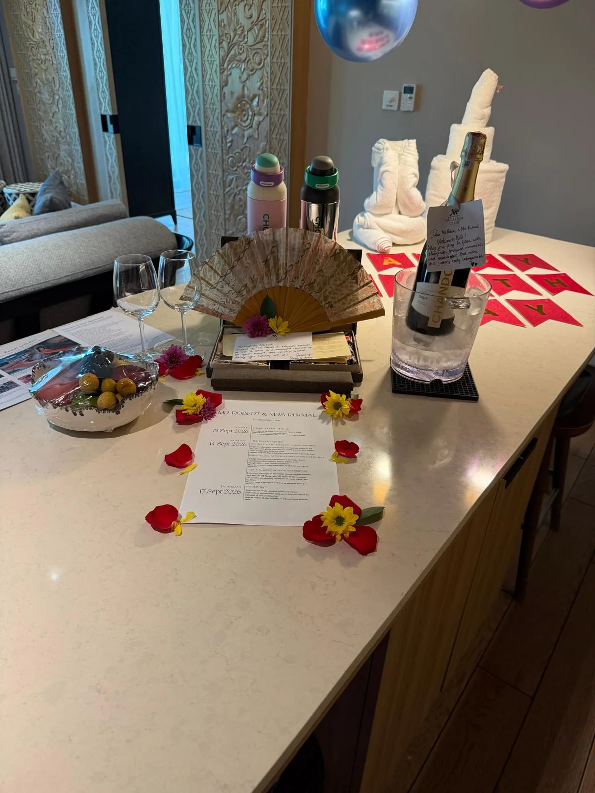 Welcome gifts, a bottle, and birthday treats arranged in the villa