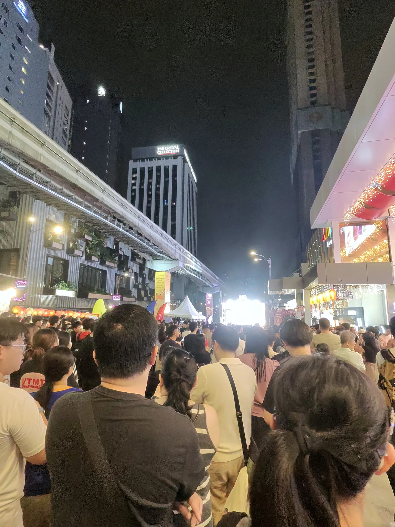 Crowds filling Bukit Bintang beneath the monorail at night